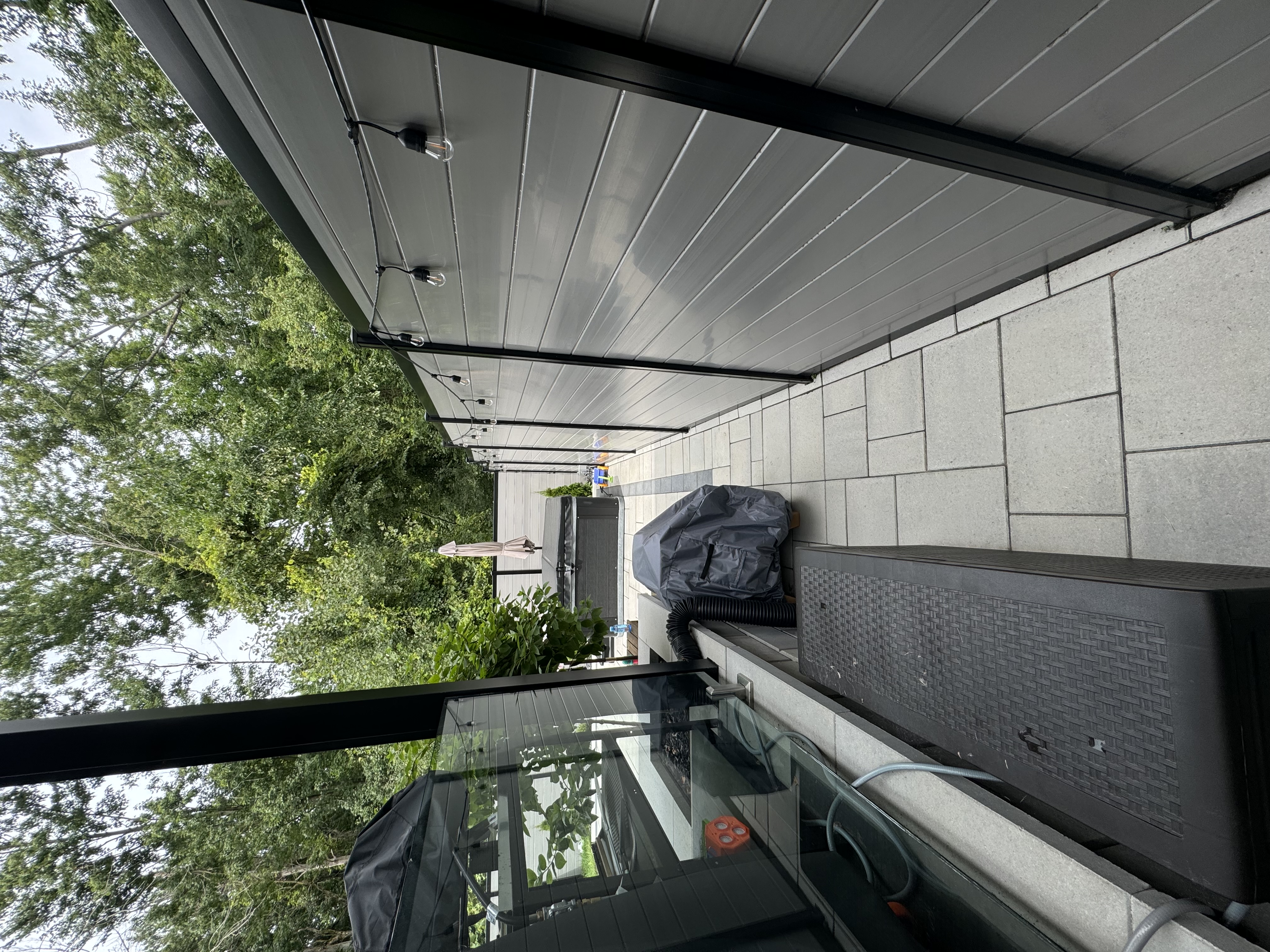 Grey hybrid fence with string lights and interlock walkway